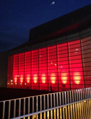 赤いライトに照らされたしこちゅ～ホールの外観写真