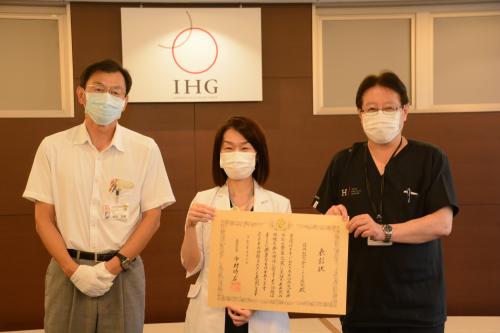 画像：表彰状を手にする石川賀代理事長と田中伸二病院長