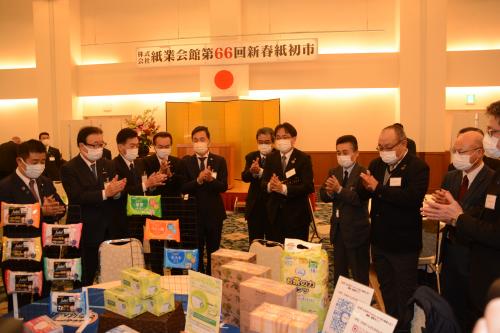 画像：商談成立を手締めで祝う新春紙初市の参加者ら