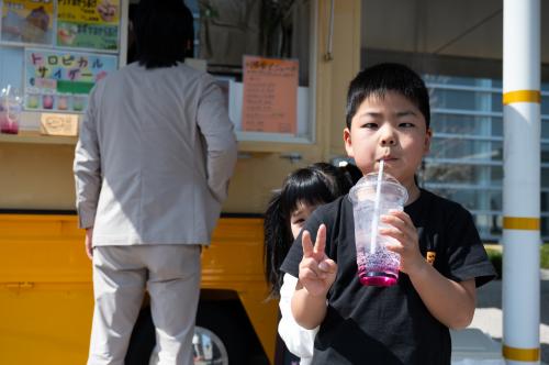 購入したドリンクを飲む子ども