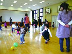 遊戯室でボール遊びをする親子の様子