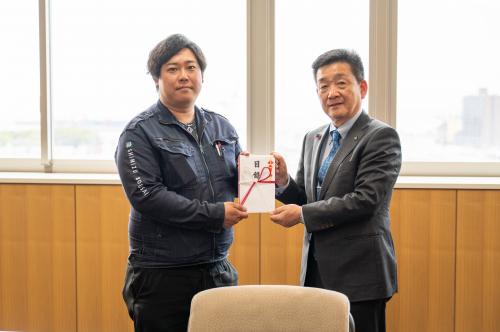 目録を手渡すシーン