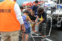 写真：給水訓練をする子どもたち