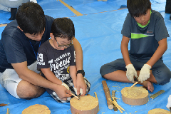 写真：大学院生と一緒竹細工を作る小学生