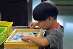 写真：真剣な眼差しで手すき和紙を作る男の子