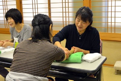 写真：アロママッサージを受ける参加者