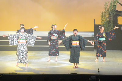 写真：歌と踊りを披露する出演者