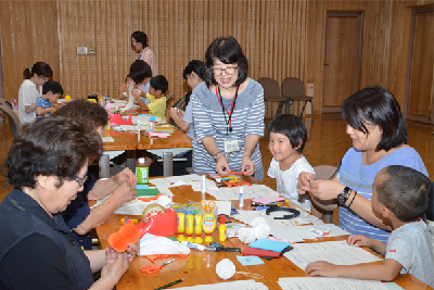 写真：センターの職員に教わりながら作品を作る参加者たち