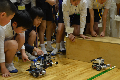 出来上がったロボットでレースをする児童ら