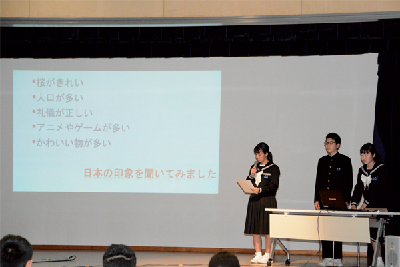 写真:舞台でスライドを使って研究成果を発表する中学生