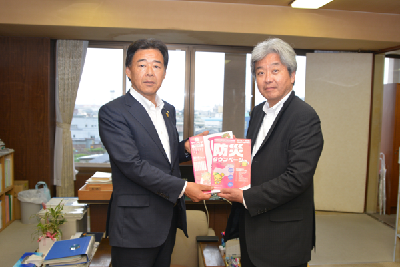 写真：贈呈されたタウンページを持って記念撮影する松本本部長と坂上副市長