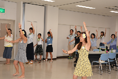 写真：講師2人にフラダンスを教えてもらう参加者たち