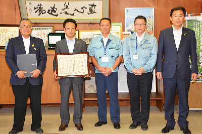 写真：三星道路（株）の代表と市長・副市長とで記念撮影