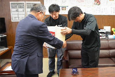 写真：集まった義援金を市長に手渡す塩田代表と松本代表