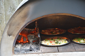 写真：簡易ピザ窯で焼く参加者の手作りピザ