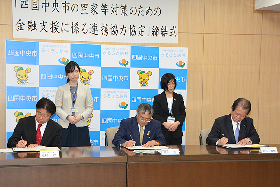 写真：協定書に署名する市長、頭取、支店長