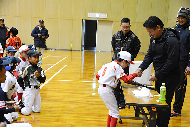 写真：抽選会でサインボールを受け取り岩村さんと握手する当選者
