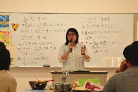 写真：講師が韓国料理について説明しているところ