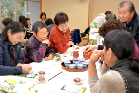 写真：新宮茶を入れながら歓談する参加者