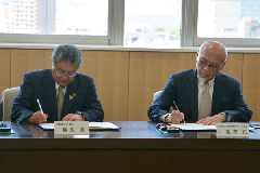 写真：協定書に署名する市長と会長