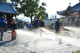 写真：消火器で消火訓練を行う参加者たち