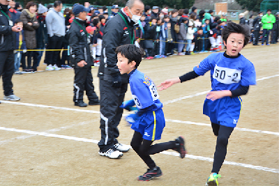 写真：たすきリレーをする小学生