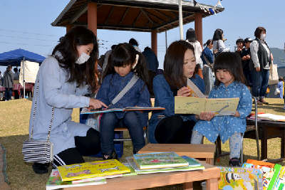 写真：じくの絵ほん屋さんで絵本を楽しむ親子