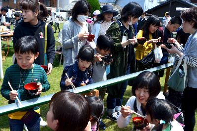 写真：そうめん流しを楽しむ親子