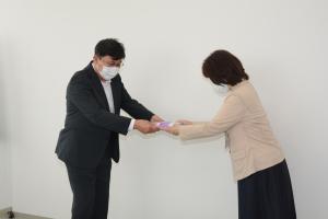 画像：野村会長から歯ブラシを受け取る大西福祉部長