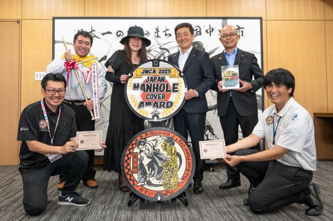 表彰式後の記念撮影(上段左から、日本マンホール蓋アワード実行委員会白浜公平様、日本マンホール蓋アワード実行委員会飯田眞三様、大西市長、河村教育長、下段左側より、書道パフォーマンス振興室井川、下水道課玉井